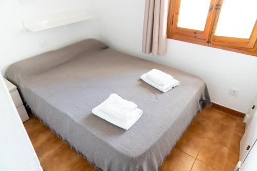 阿雷纳尔登卡斯特尔Apartamento Menorca Arenal d'en Castell的房间里的一张床位,上面有两条白色毛巾