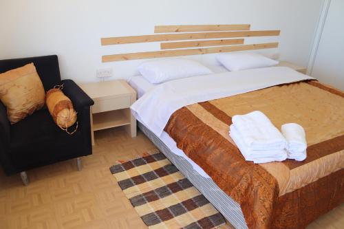 MaroniSummer Dream Cyprus的一间卧室配有一张大床和一把椅子