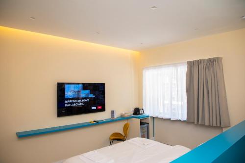那不勒斯South Hands Luxury Rooms的卧室设有壁挂式电视和床。