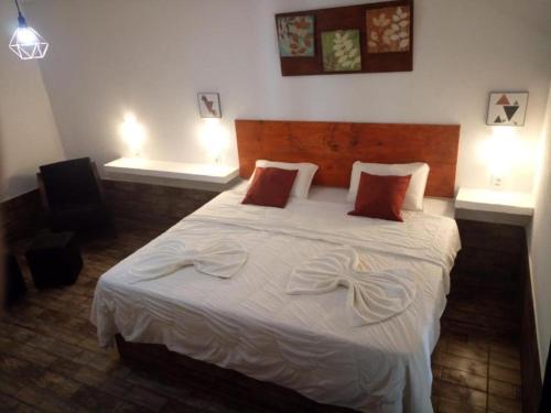 特雷索波利斯Pousada Tarkna的一间卧室配有带白色床单和红色枕头的床。