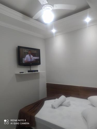 阿帕雷西达Pousada Quarto Casal com ar,frigobar, garagem的客房设有两张床和一台墙上的电视