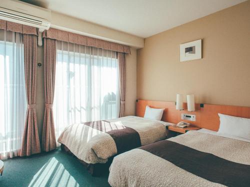 冈山冈山吴竹酒店的酒店客房设有两张床和窗户。