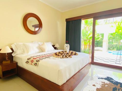 罗威那Villa Serenity的一间卧室配有一张带镜子的床和窗户