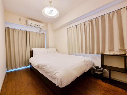 东京PRISM COURT 綾瀬的卧室配有白色的床和窗户。