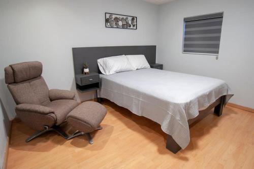 恩塞纳达港Clean&Equipped, 1-Floor 3-Bedroom Downtown House的一间卧室配有一张床和一对椅子