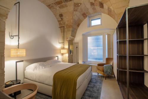 莱切Palazzo De Noha - Boutique Hotel的一间卧室设有一张大床和一个窗户。