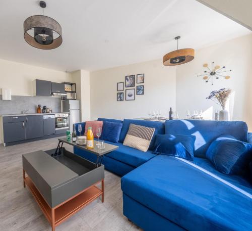 圣康坦Les Appartements de la Nef d'Or的客厅设有蓝色沙发,配有厨房