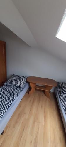 CięcinaAgroturystyka u Wiesi的客房设有两张床和一张木桌。