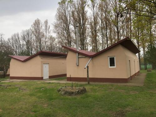 蒂萨菲赖德Tóparti Camping的田野上带红色屋顶的小房子