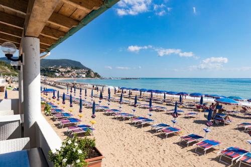 努马纳Casabianca Appartamenti的海滩上设有椅子和遮阳伞,还有大海