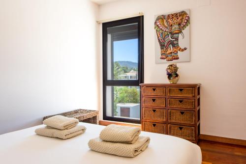 圣何塞德萨塔莱阿Villa Sa Marinada | 100m de Mar的一间卧室设有一张床和一个窗口