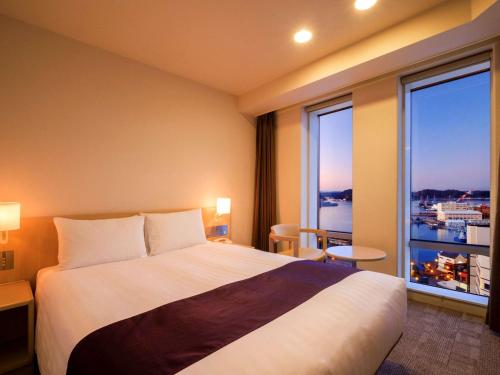 横须贺市Mercure Yokosuka的酒店客房设有一张床和一个大窗户