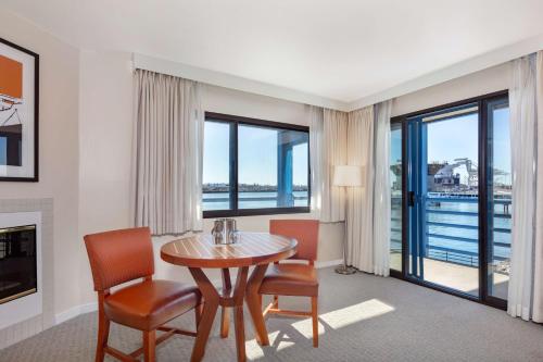 奥克兰Waterfront Hotel, part of JdV by Hyatt的客厅配有桌椅和大窗户