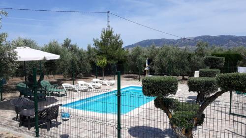 波索阿尔孔Casa Rural El Parral, Sierra Cazorla的度假村前方带游泳池的围栏