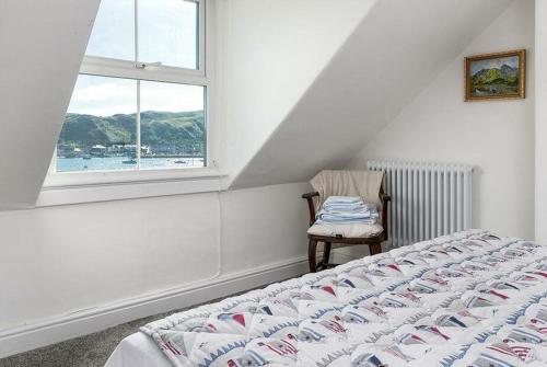 康威Haulfryn Apartment的卧室配有床、椅子和窗户。