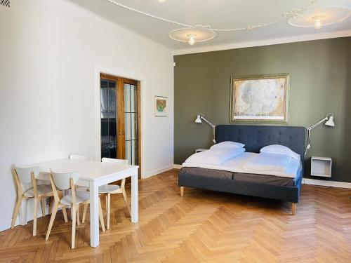 腓特烈港aday - Frederikshavn City Center - Luxurious room的卧室配有一张床和一张桌子及椅子