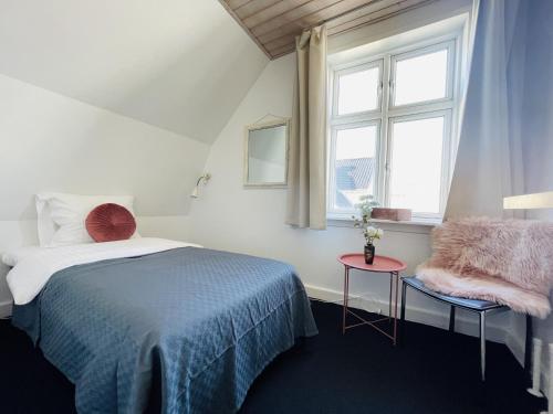 腓特烈港aday - Frederikshavn City Center - Single room的一间卧室设有一张床、一个窗口和一张桌子