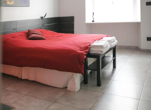 都灵Auri's House的一间卧室配有红色的床和一张带毛巾的桌子
