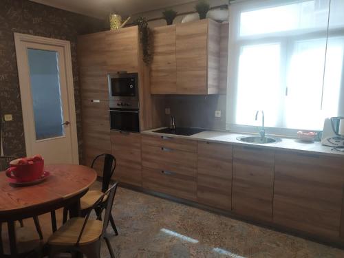 毕尔巴鄂bilbao center apt 90´s PARKING的厨房配有木制橱柜、桌子和窗户。