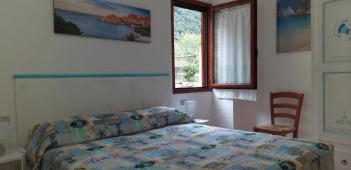 多尔加利Casa Lucia Campagna Relax的卧室配有床、椅子和窗户。