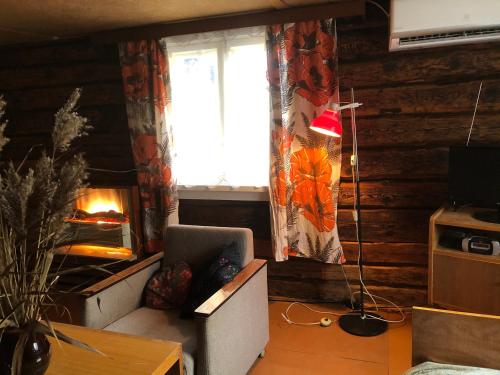 Väike-RakkeVedru Puhketalu的客厅设有壁炉、椅子和窗户