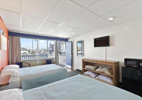 大洋城Blue Wave Inn - Ocean City的酒店客房设有两张床和一台平面电视。