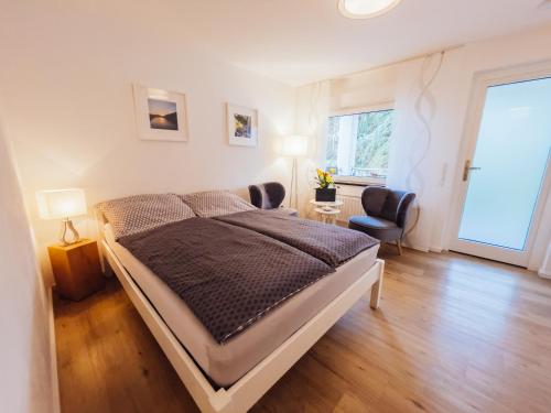 贝尔恩卡斯特尔-库斯Ferienwohnung Mosel的卧室配有床、椅子和窗户。