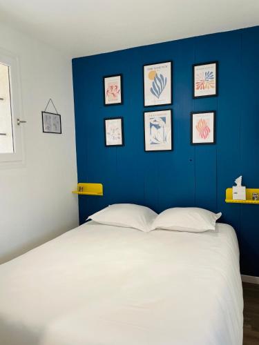 吉伦特河畔梅谢尔Logis des pêcheurs的一间卧室设有蓝色的墙壁和白色的床。