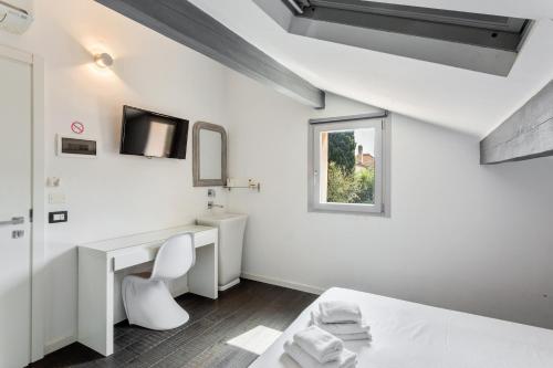 圣特罗佩Maison d' Orange - Chambres的白色的客房配有一张床和一张书桌