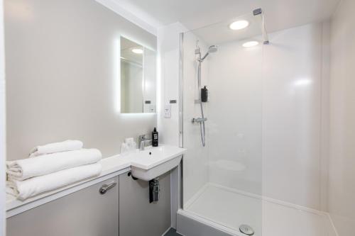 普里茅斯宜必思普利茅斯酒店的带淋浴和盥洗盆的白色浴室