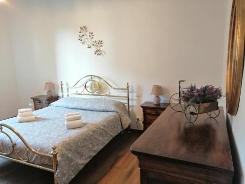 托里塔迪谢纳La Dimora degli Olivi的一间卧室配有一张床和一张鲜花桌子