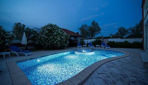 普拉Villa Filip - Private Pool & Gym的夜间在院子里的游泳池