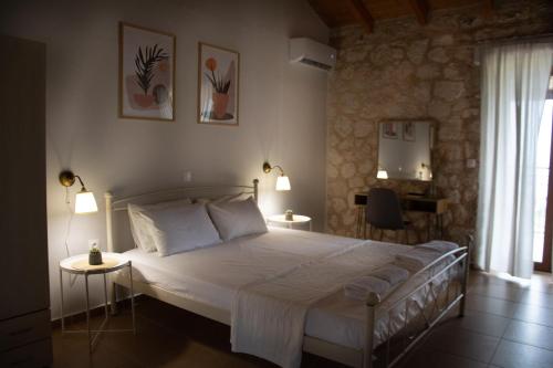 雅莎尼奥Noemie Studios的一间卧室配有一张带两张桌子和两盏灯的床。
