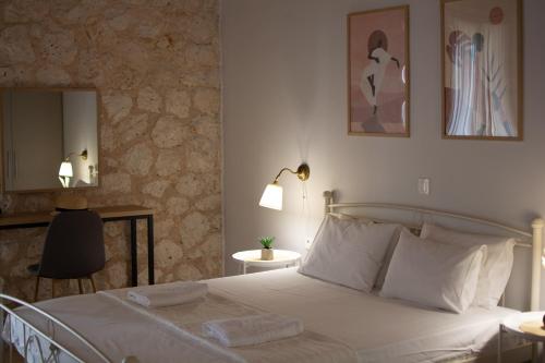 雅莎尼奥Noemie Studios的卧室配有白色的床和镜子