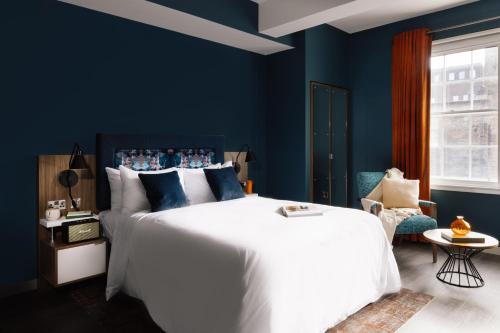 爱丁堡Native Edinburgh的一间卧室配有一张带蓝色墙壁的大床