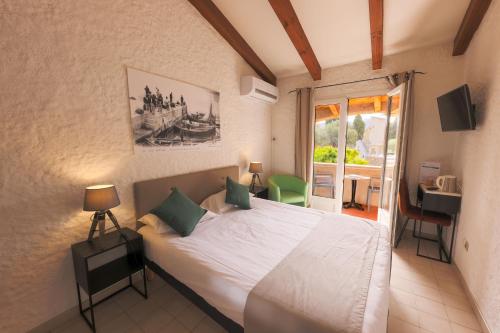 利勒鲁斯Hôtel Casa Rossa & Spa的一间带大床的卧室和一个阳台