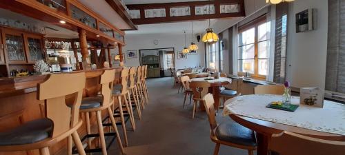霍盖思Hotel Silbertanne的一间带桌椅的餐厅和一间酒吧