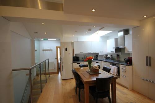剑桥Cambridge city centre immaculate 2 bed apartment的一间带木桌的厨房和一间餐厅