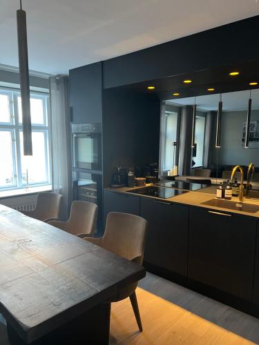 哥本哈根Luxury new apartment - Heart of Copenhagen的厨房配有桌椅和水槽。