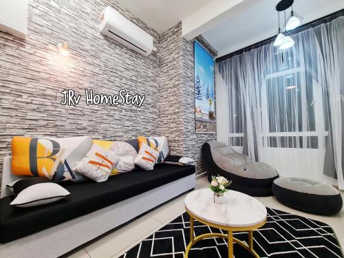 马六甲JRv HotelStyle HomeStay Melaka的客厅配有黑色沙发和砖墙