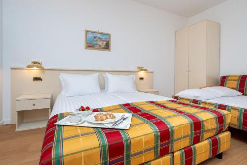 扎托尔Villa Królewiec - 1,5km od Energylandii的一间酒店客房,配有两张床和一盘食物