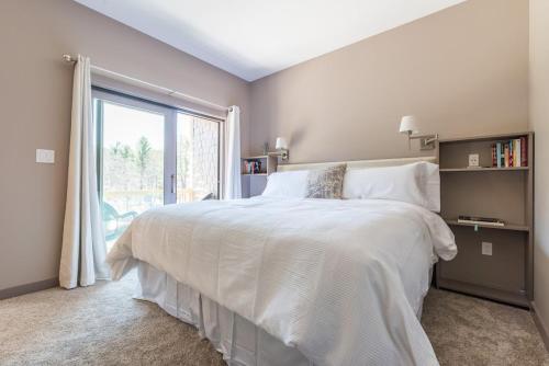 SpencertownSpencertown Inn的卧室设有一张白色大床和一扇窗户。