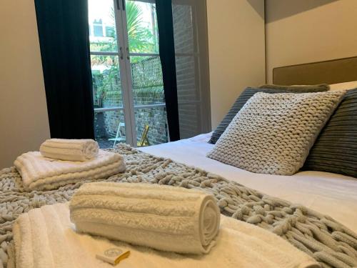 伦敦Luxury Fulham Flat with 5* touches nr River Thames的卧室配有2条毛巾。