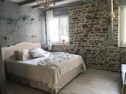 Ménil-Hubert-sur-Orne"La chambre des TISSERANDS"的一间卧室设有一张床和砖墙