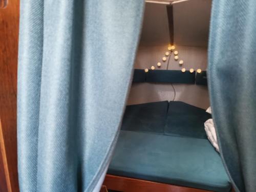 奈达JūraMiške的客房内的双层床配有蓝色窗帘