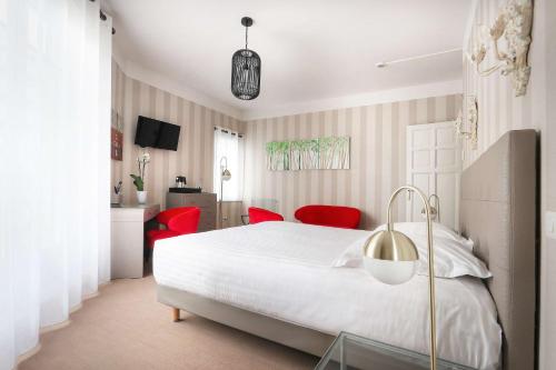 拉波勒贝斯特韦斯特布列塔尼拉博勒中心酒店的卧室配有白色的床和红色椅子