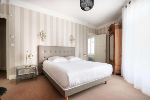 拉波勒贝斯特韦斯特布列塔尼拉博勒中心酒店的卧室配有一张白色大床和条纹墙