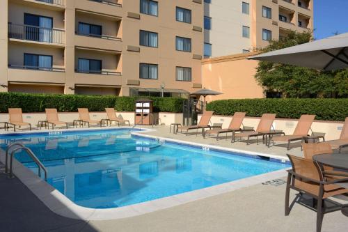 达拉斯Sonesta Select Dallas Central Expressway的一个带椅子的游泳池和一间酒店