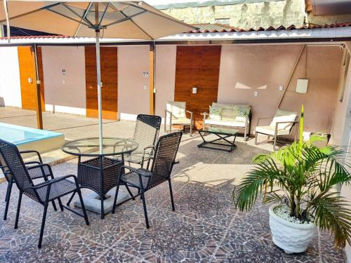 马瑙斯Residencial Napolitan的庭院配有桌椅和遮阳伞。