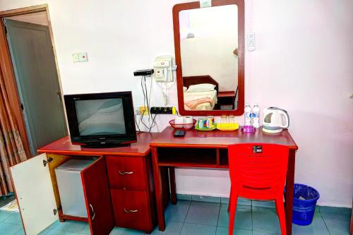 瓜埠The Room Concept Homestay的一张红色的桌子,配有电视和镜子